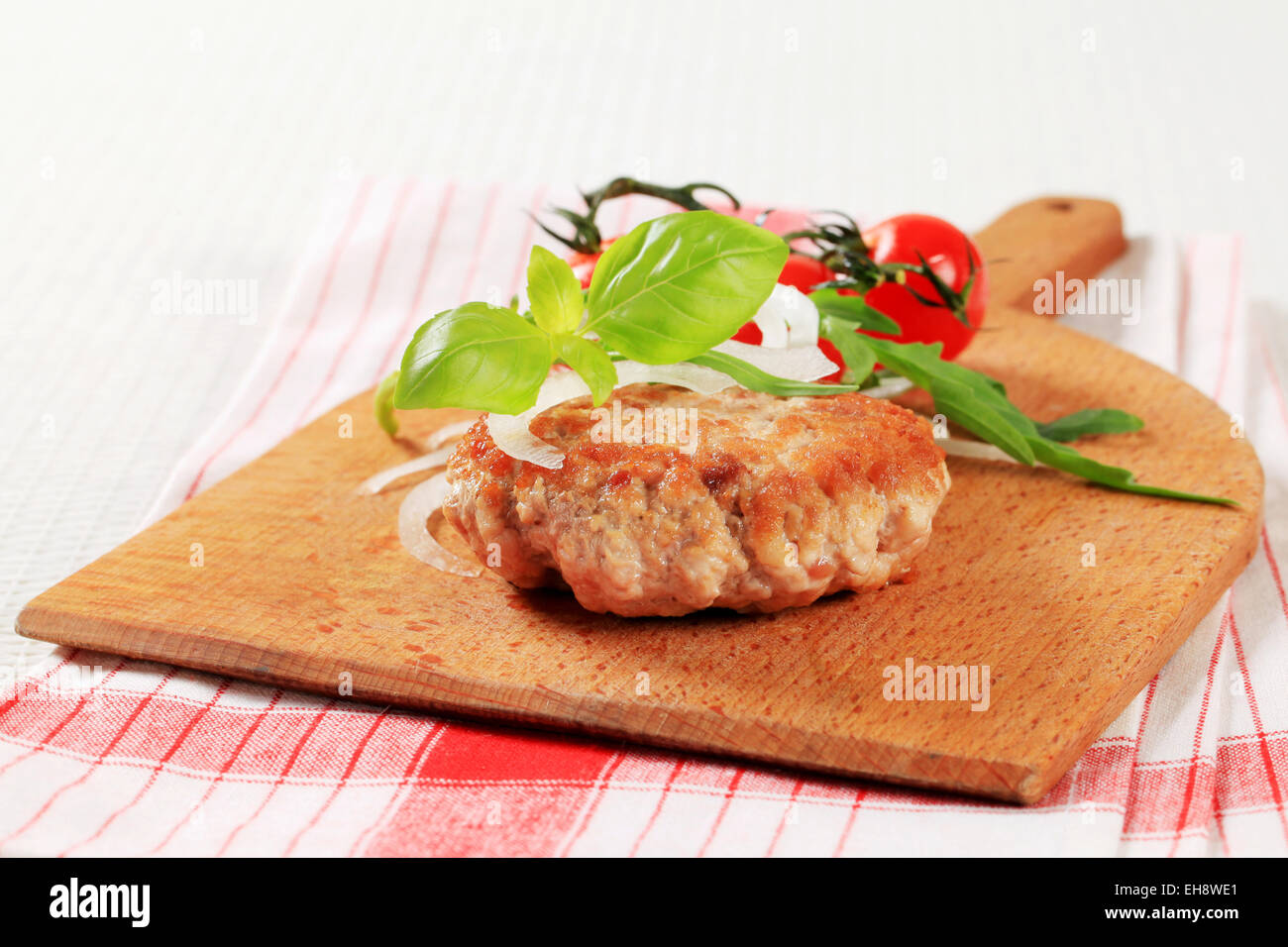 Pan fried meat patty on a cutting board Stock Photo