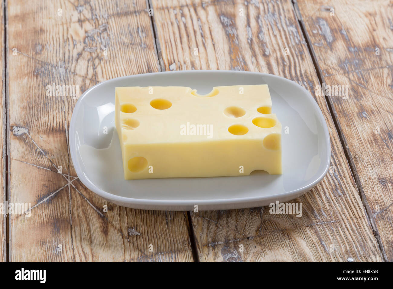 Piece of Cheese on rustic wooden table Stock Photo