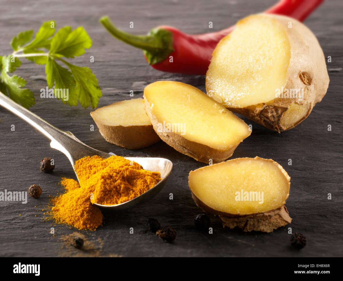 Fresh ginger root, red chili & ground turmeric. Indian spices composed arrangement Stock Photo