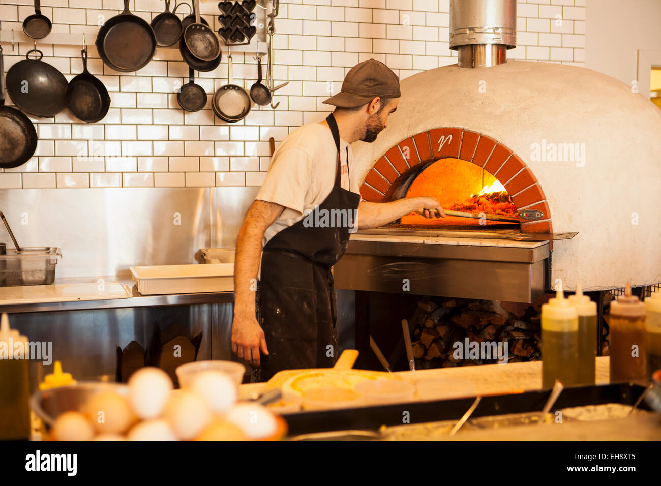 chef placing pizza in a traditional brick oven, Industrial Eats, Buellton, California Stock Photo