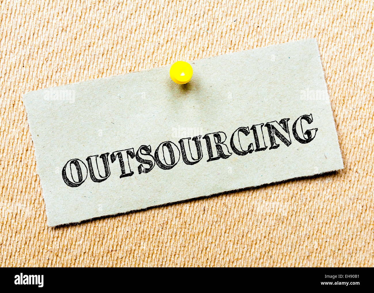 Recycled paper note pinned on cork board. Outsourcing Message. Concept