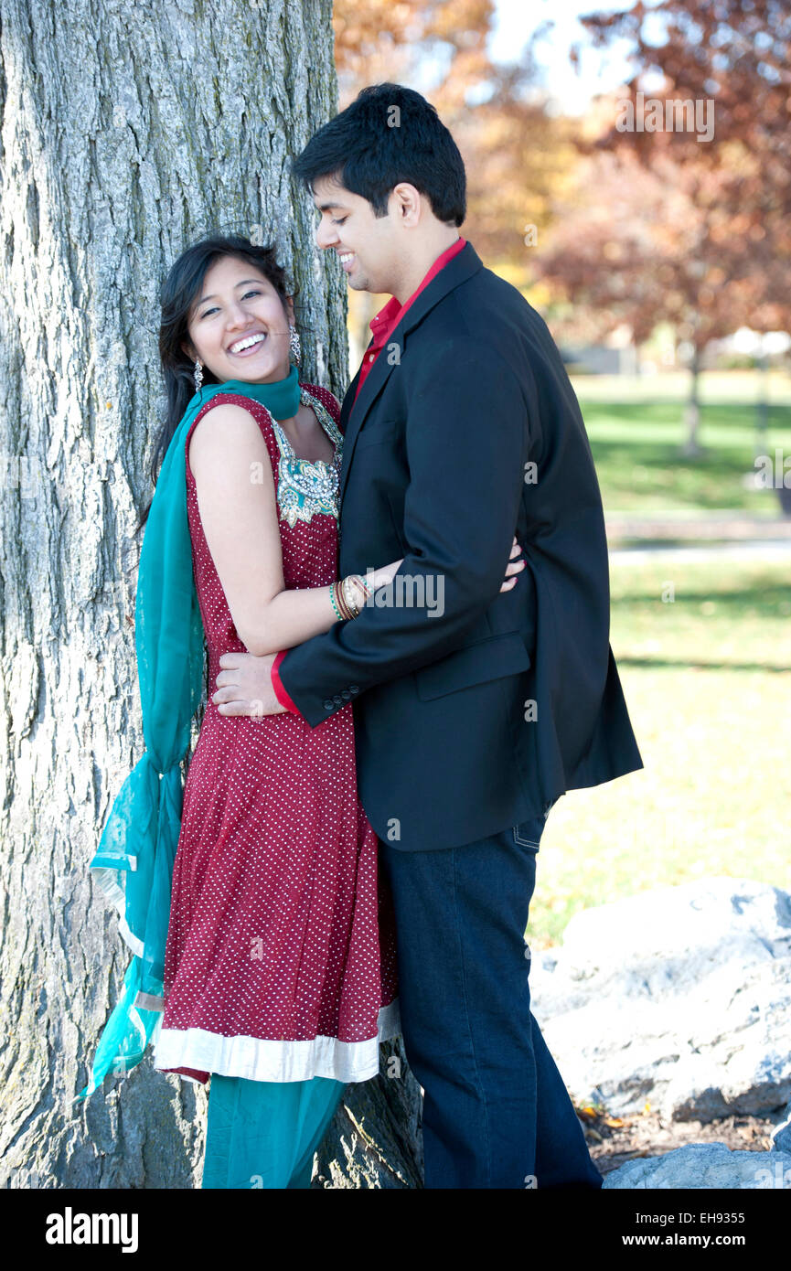 A young and happy Indian couple looking at each other in the fall near ...