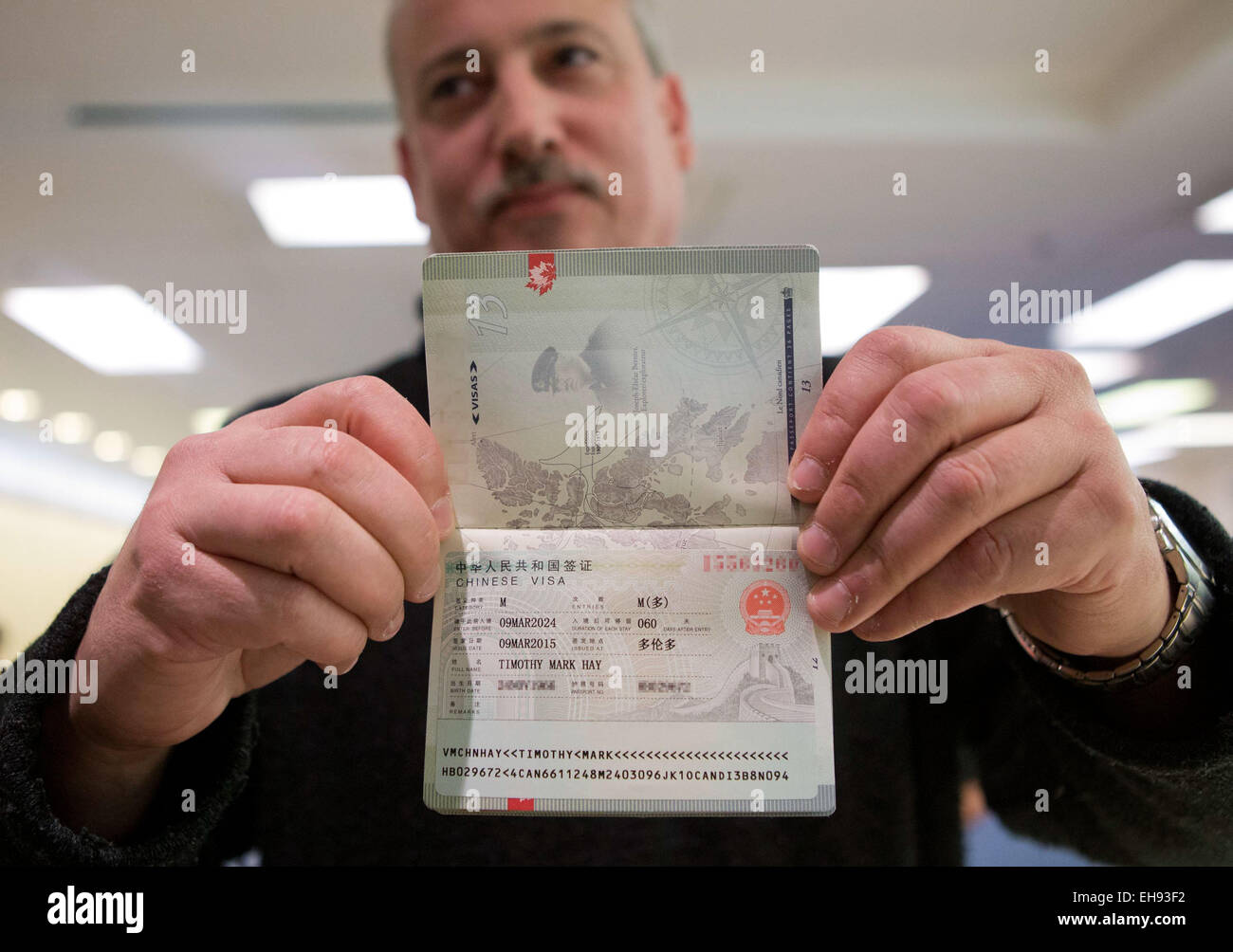 150310)-- TORONTO, March 10, 2015 (Xinhua)-- Timothy Mark Hay shows the  first visa to China with validity period of 10 years he got at Chinese Visa  Application Service Center in Toronto, Canada,
