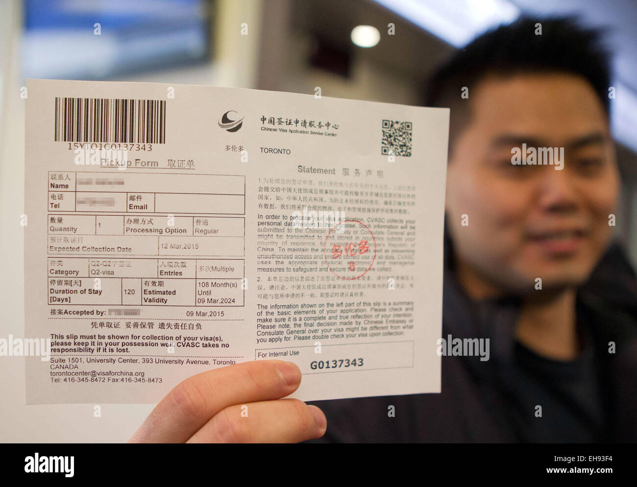 150310)-- TORONTO, March 10, 2015 (Xinhua)-- A man shows the pickup form of  his visa to China at Chinese Visa Application Service Center in Toronto,  Canada, March 9, 2015. Chinese embassy and