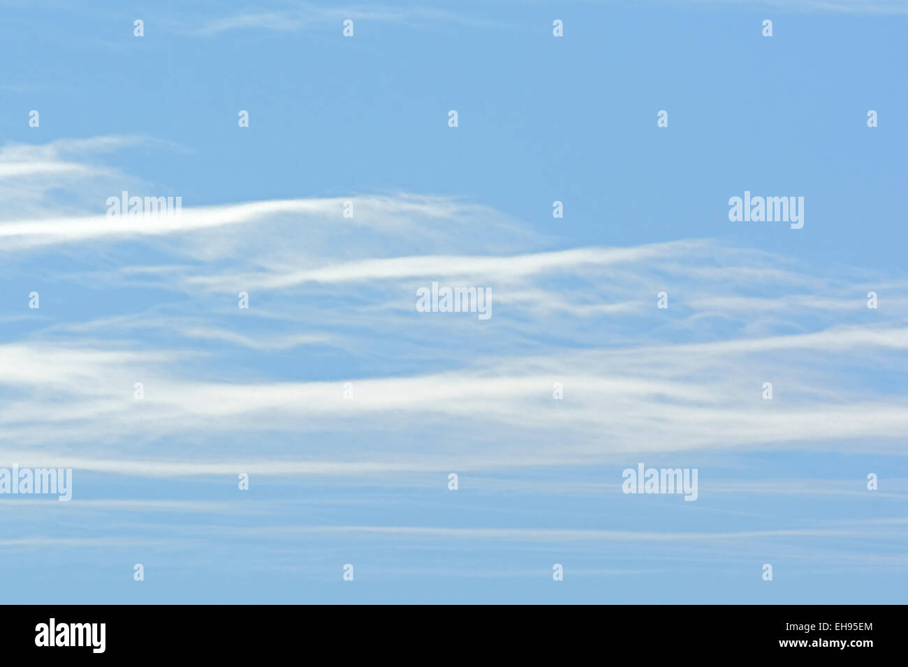 Altostratus clouds glide in a blue sky on a winters day. Stock Photo
