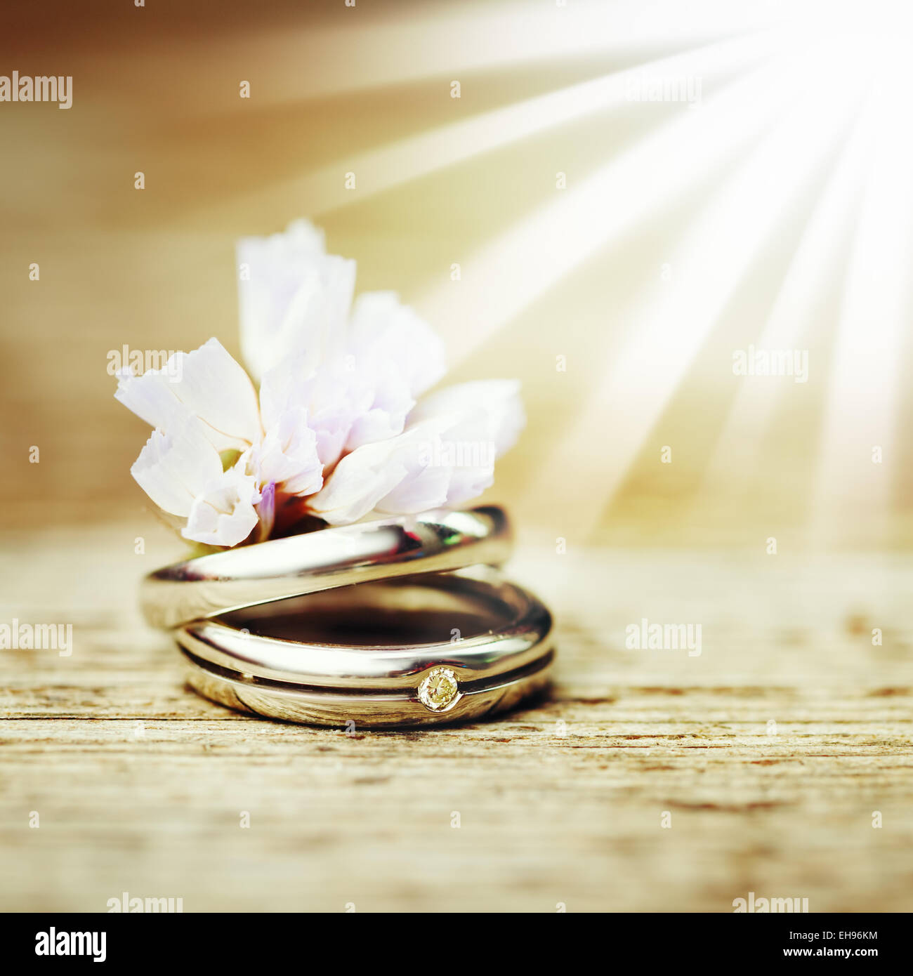 Wedding Engagement Rings Close Up With Cute Wild Flower On Wood