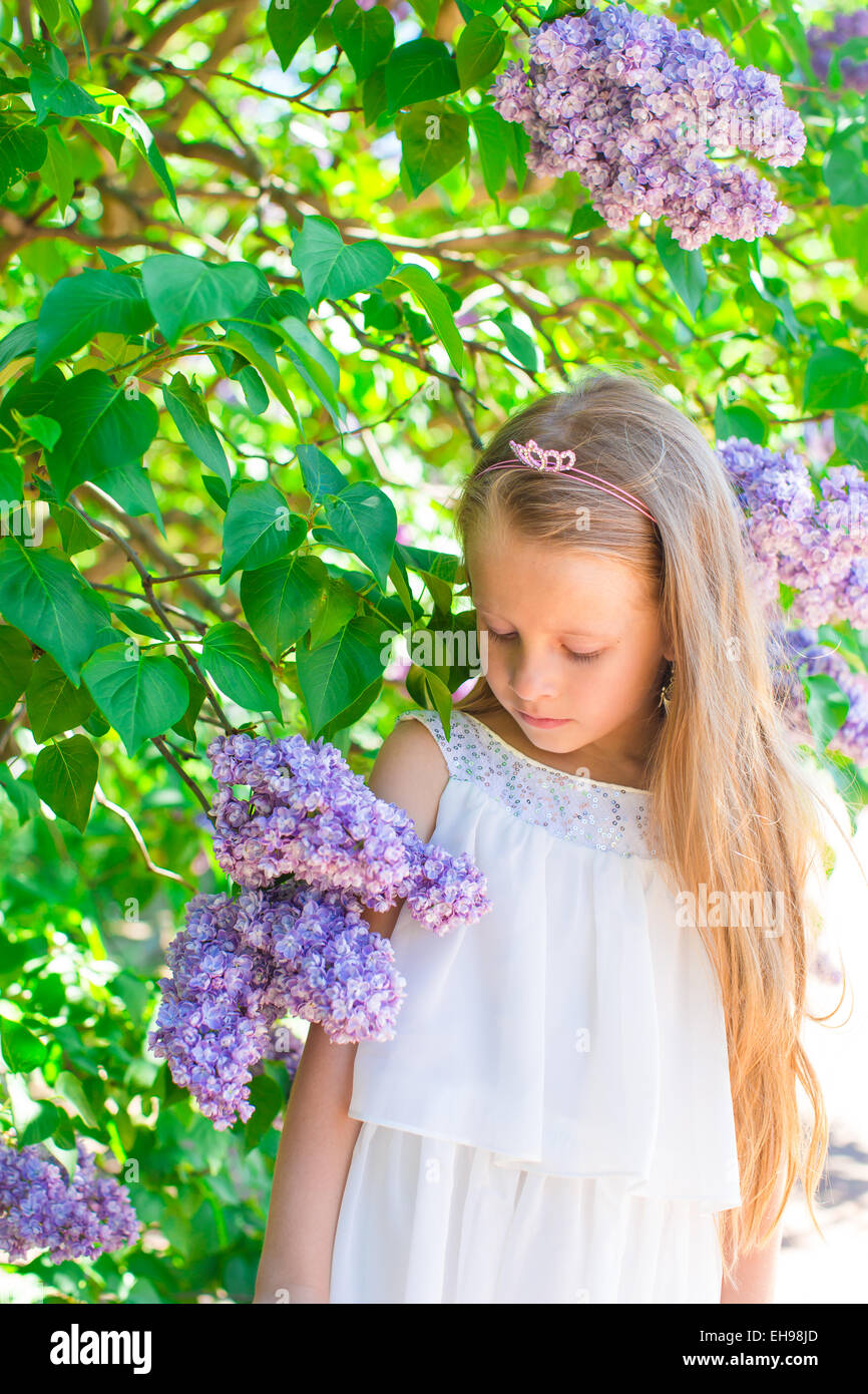 Adorable happy little girl in flower blossoming garden Stock Photo - Alamy