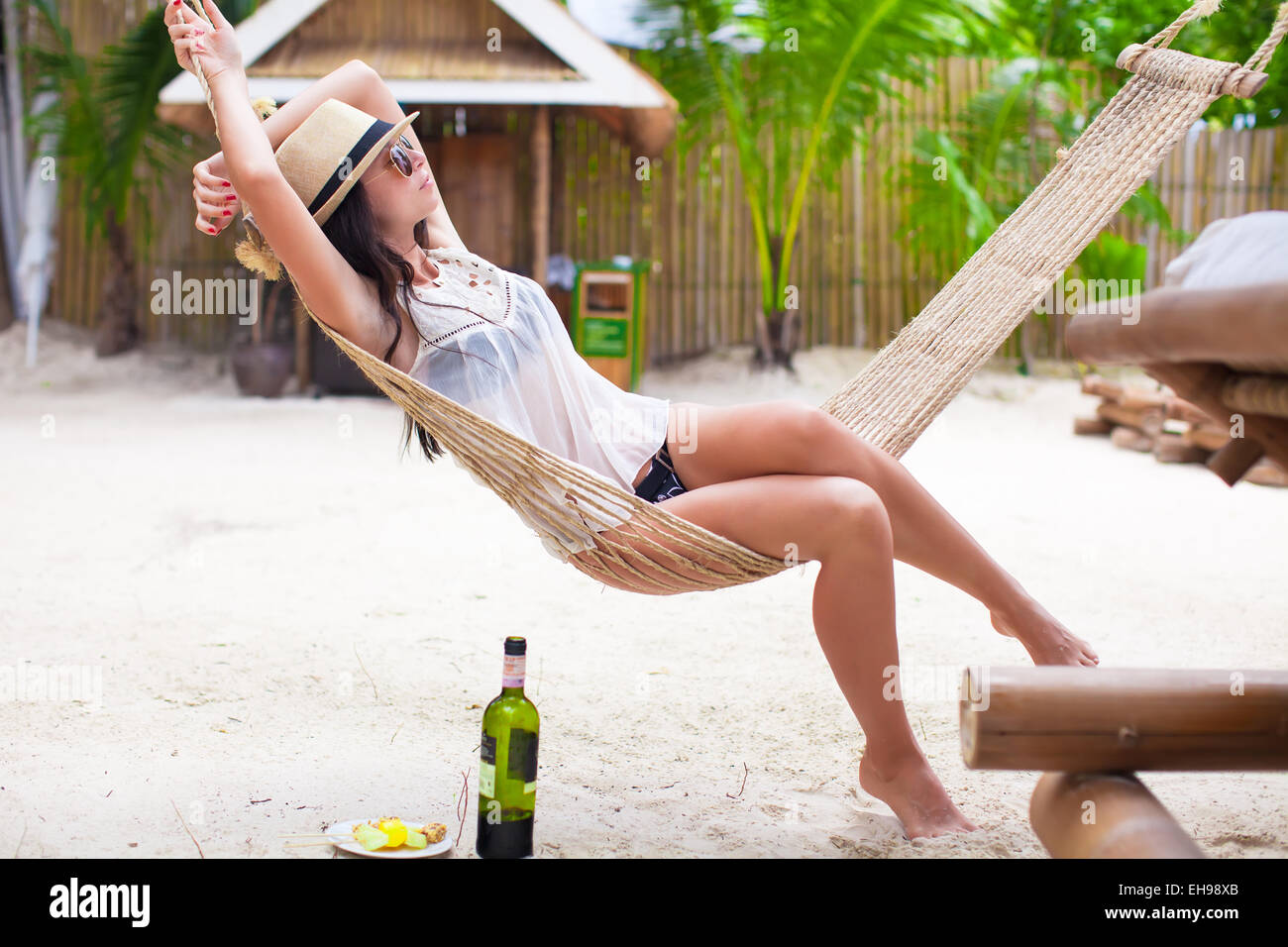 Happy young woman lying in hammock on tropical beach Stock Photo - Alamy