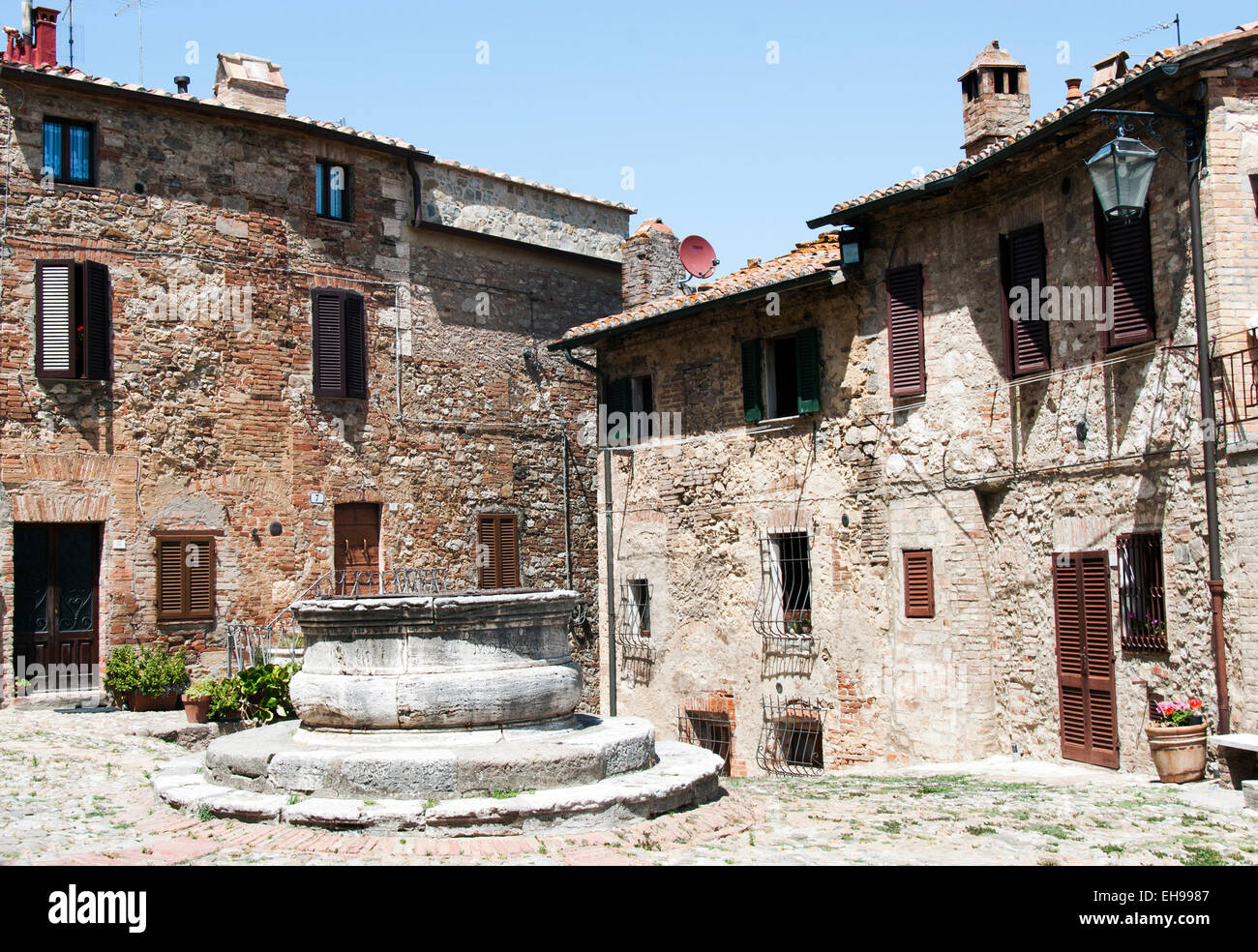 ancient square with water well in the italian old town Castiglione d' Orcia, Tuscany Italy Stock Photo
