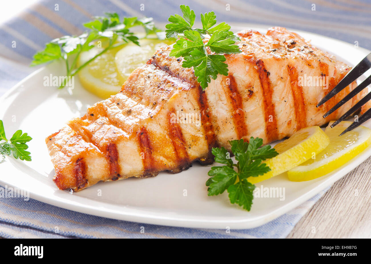 Grilled Salmon with lemon and  fresh herbs . Selective focus Stock Photo