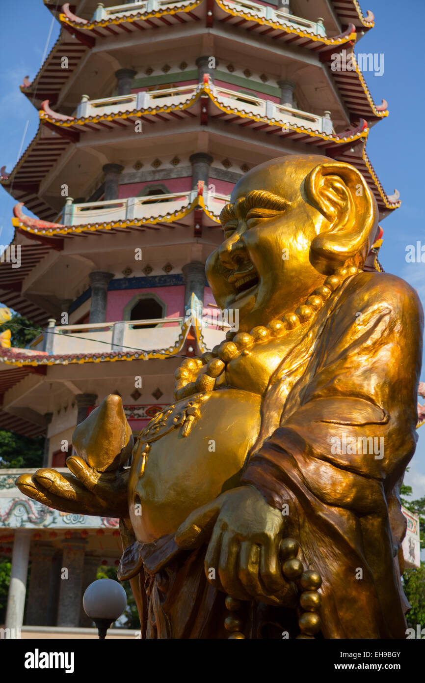 Statue of laughing Buddha in a background of the pagoda at Pulo Kemaro (Kemaro island) temple complex in Palembang, South Sumatra, Indonesia. Stock Photo