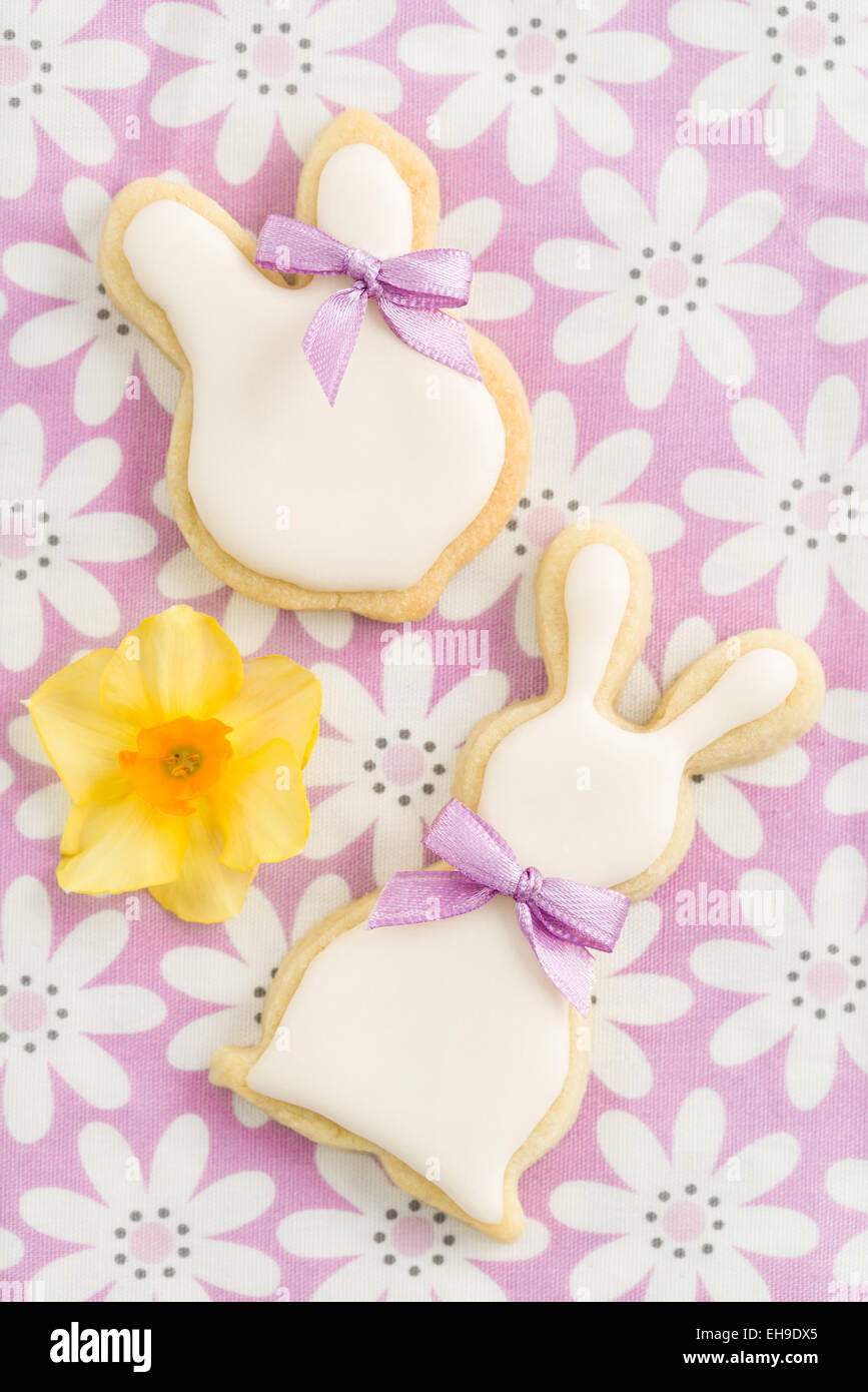 Easter bunny sugar cookies with cute ribbon bows on pink chequered tablecloth Stock Photo