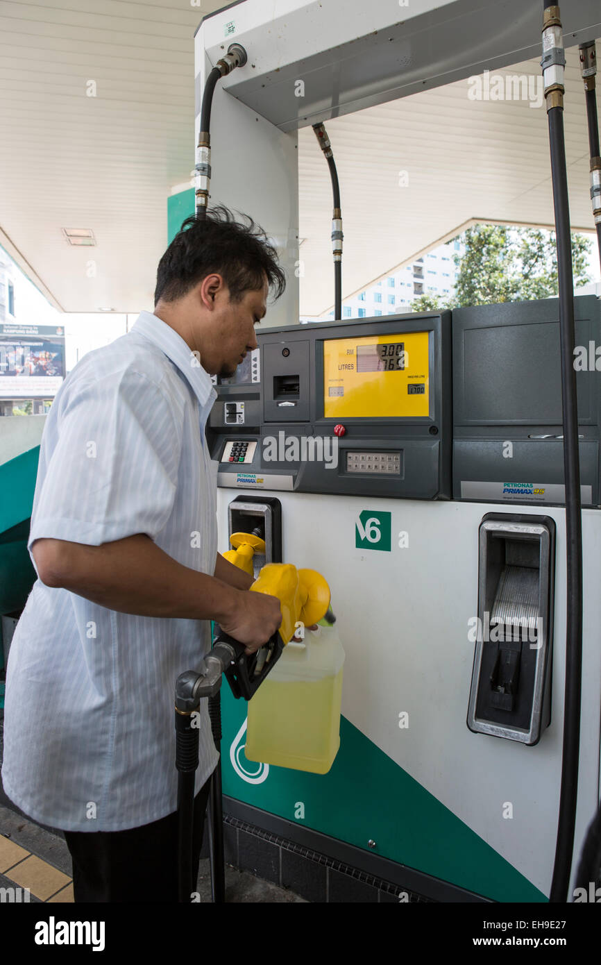 A customer fills a plastic can at a Pertoliam Nasional Bhd. (Petronas) gas station in Kuala Lumpur, Malaysia Stock Photo