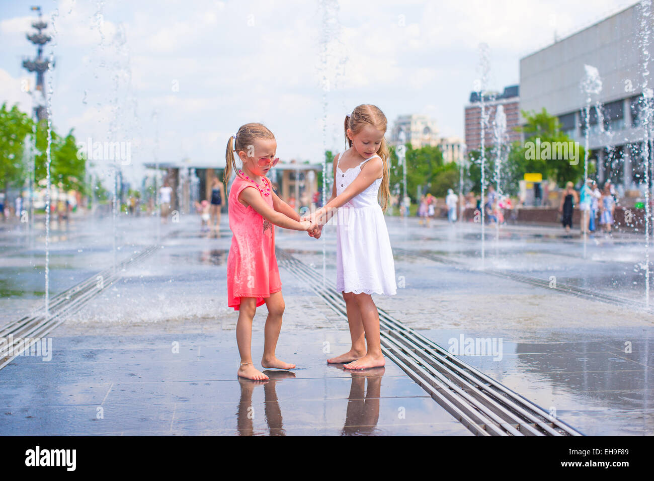 Little girls enjoy sunny day in outdoors fountain Stock Photo - Alamy