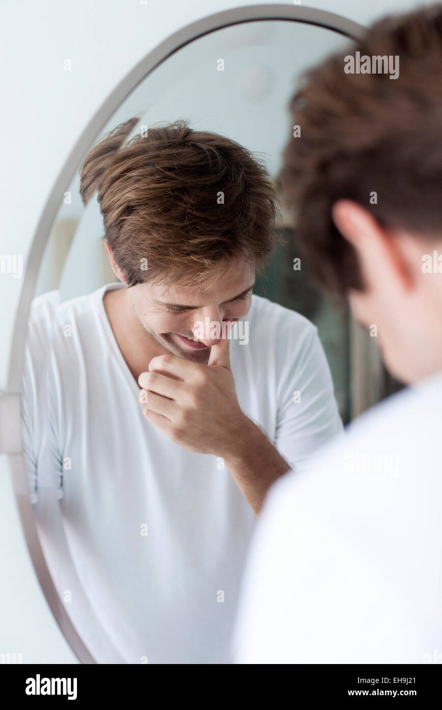 Man laughing to self, reflection in mirror Stock Photo