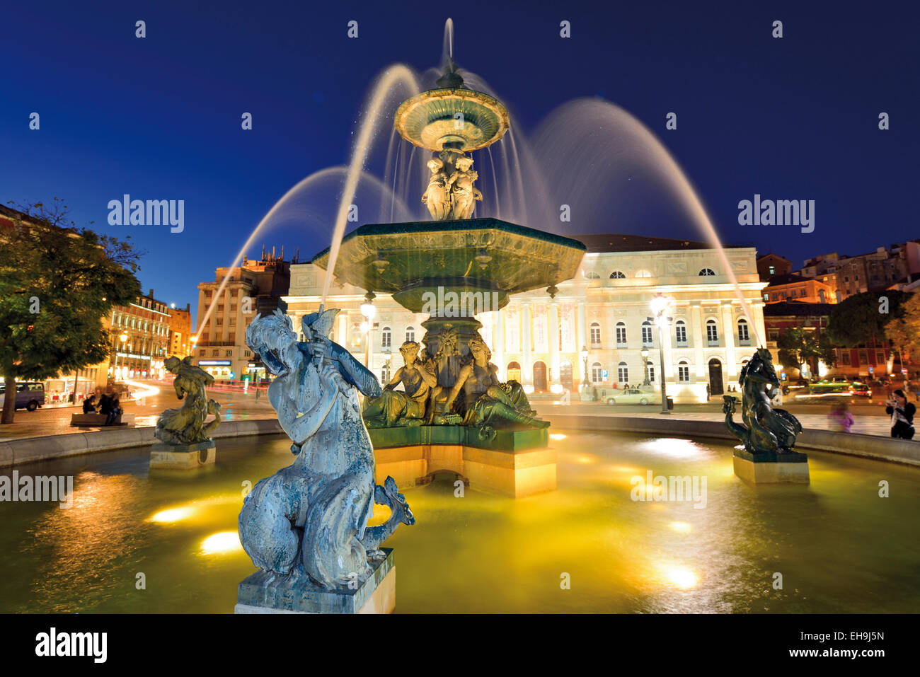 Portugal, Lisbon: Nocturnal illuminated water fountain at Rossio ou Pedro IV Square in downtown Stock Photo