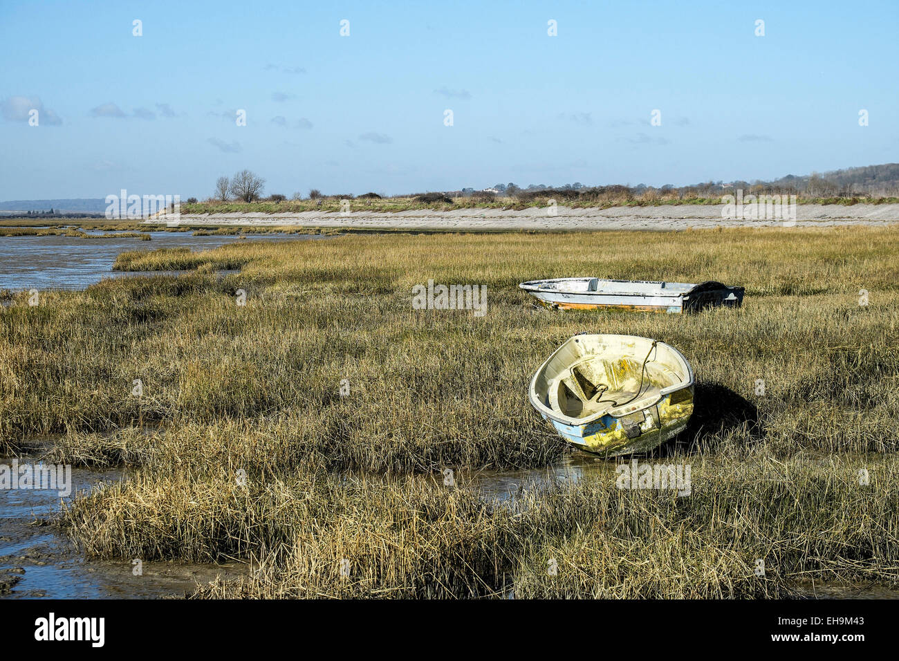 Dinghies tied up at low tide on the banks of Two Tree Island in Essex. Stock Photo