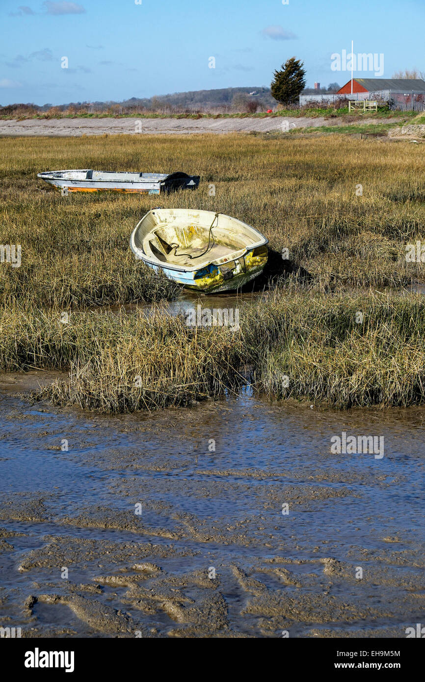 Dinghies tied up at low tide on the banks of Two Tree Island in Essex. Stock Photo