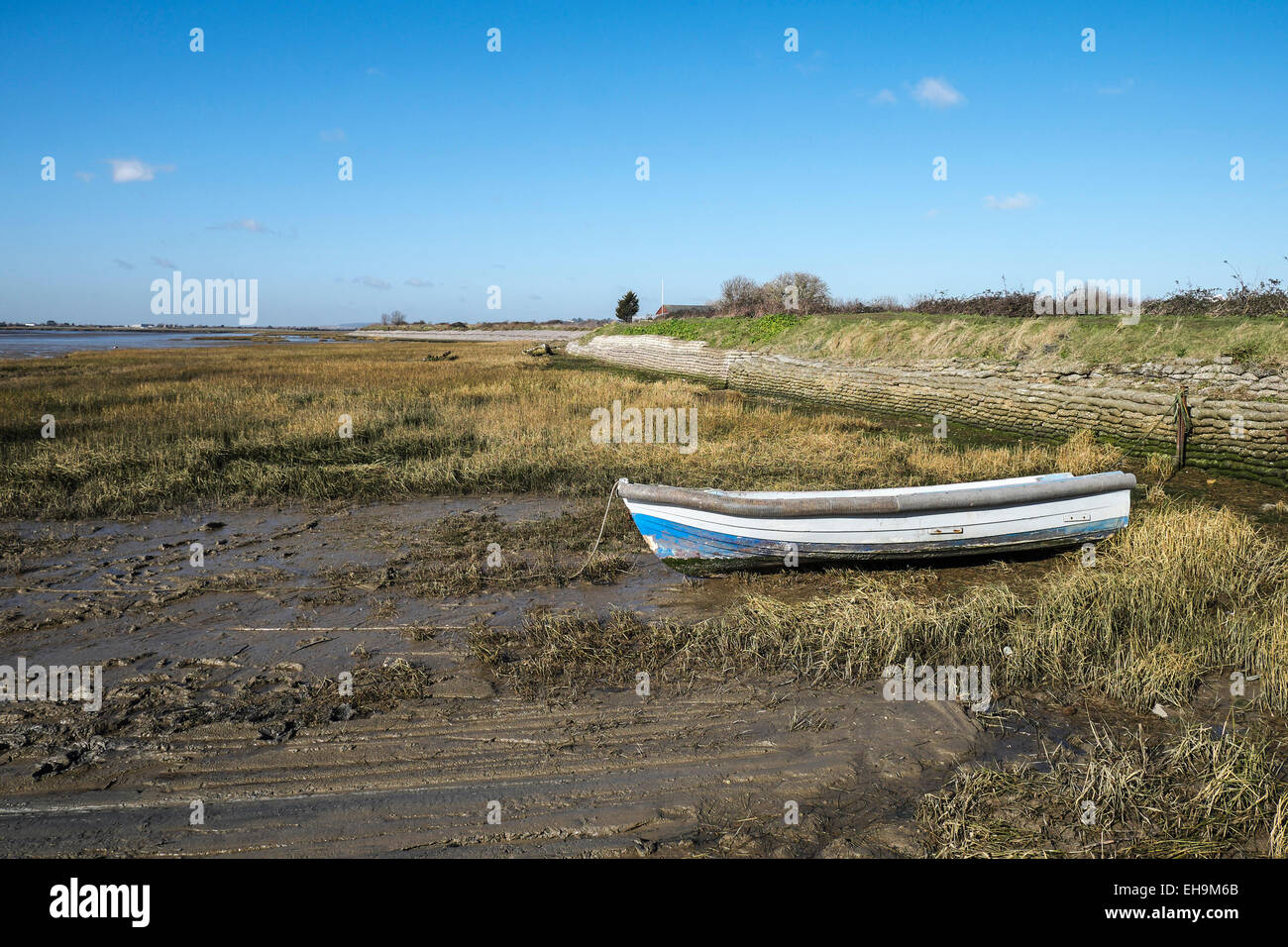 A dinghy tied up at low tide on the banks of Two Tree Island in Essex. Stock Photo