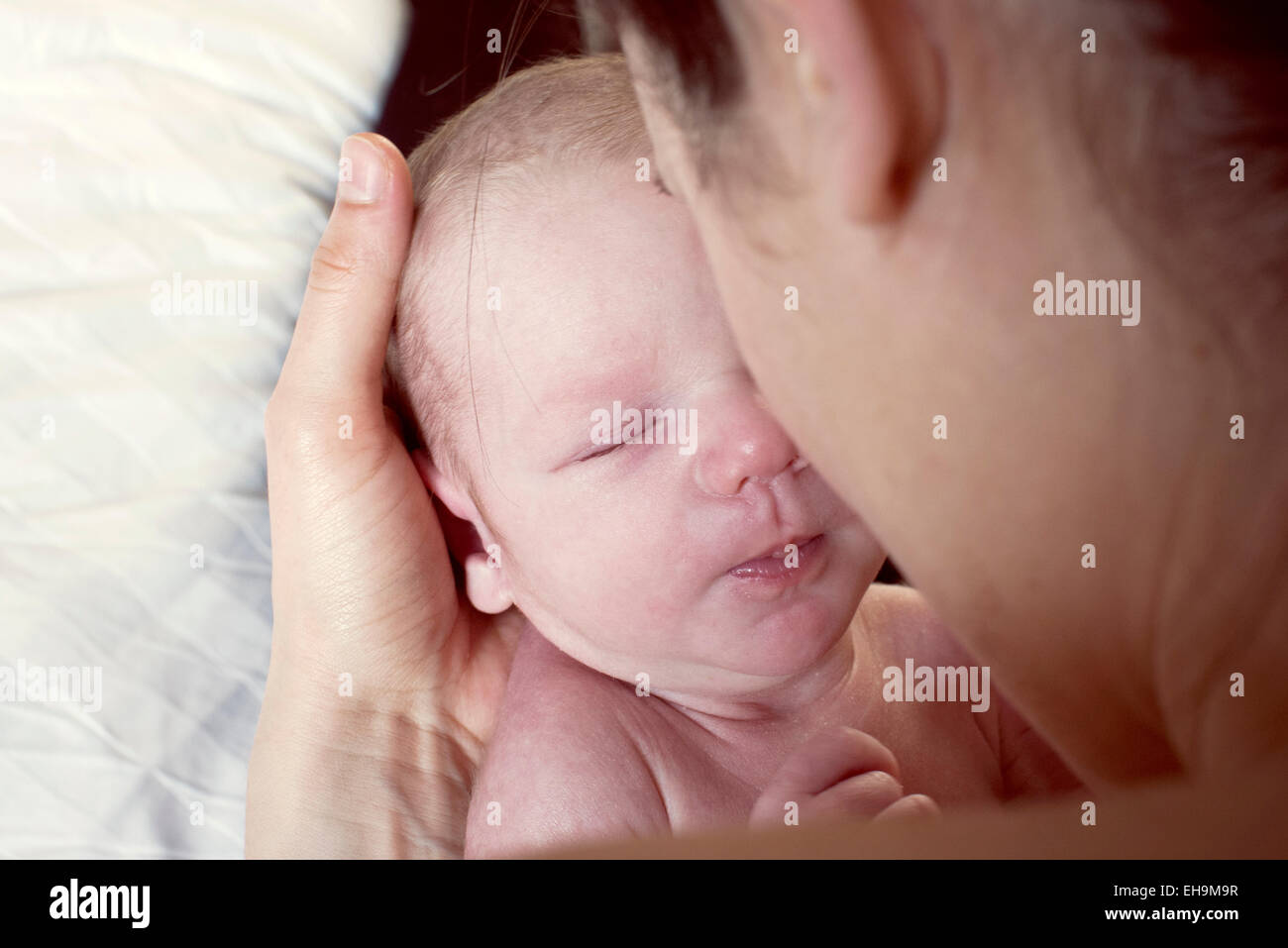 Mother bonding with newborn baby, over the shoulder view Stock Photo