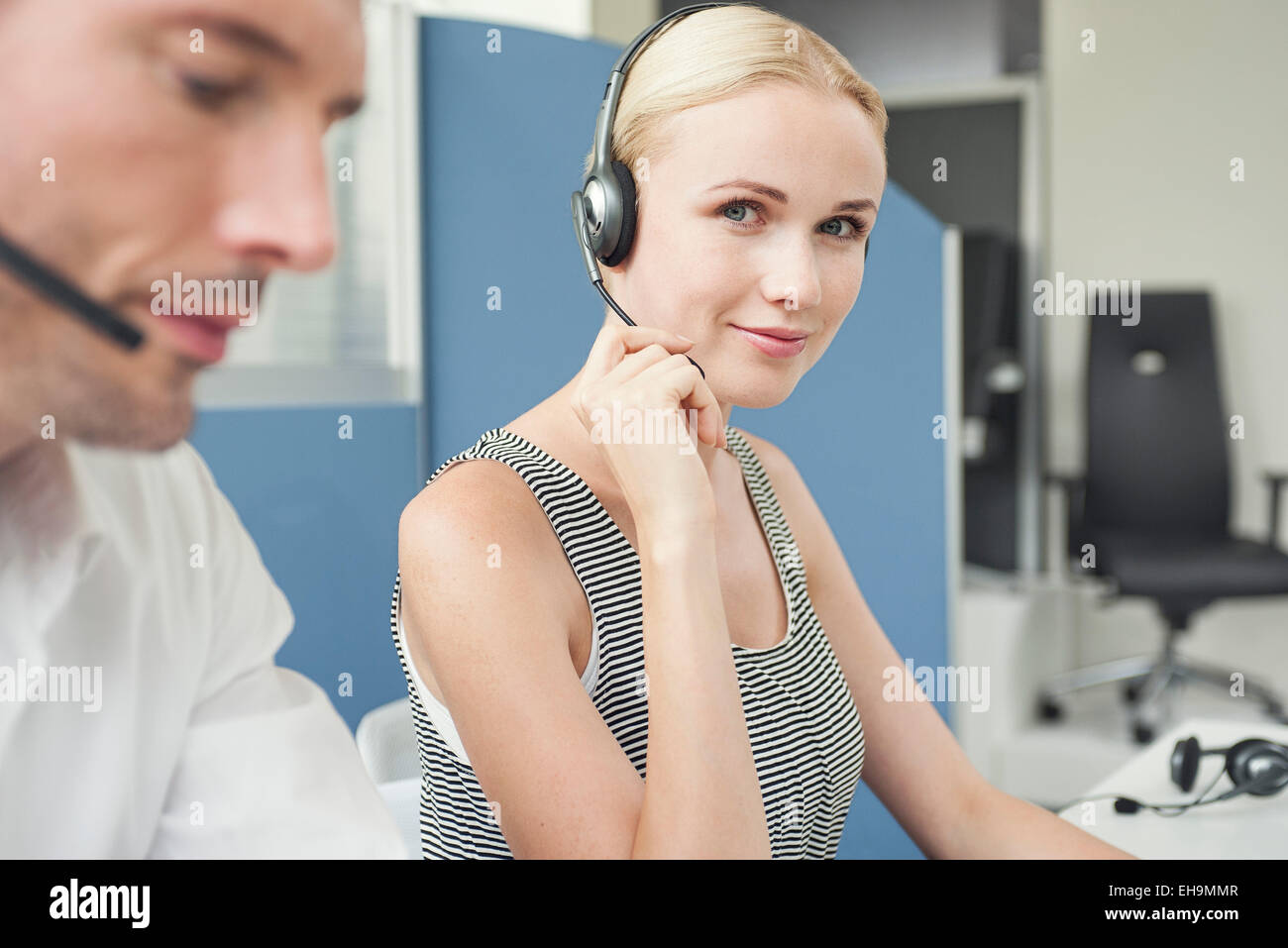 Woman wearing phone headset at desk Stock Photo