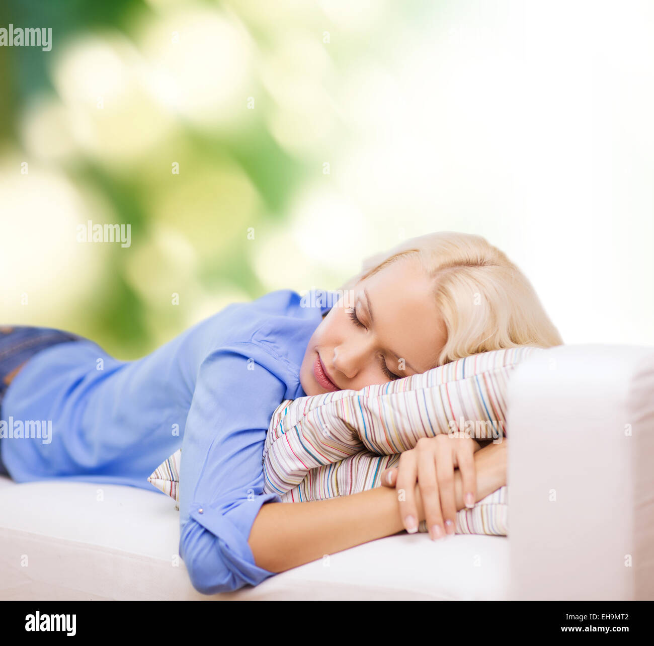 smiling young woman lying on sofa Stock Photo - Alamy