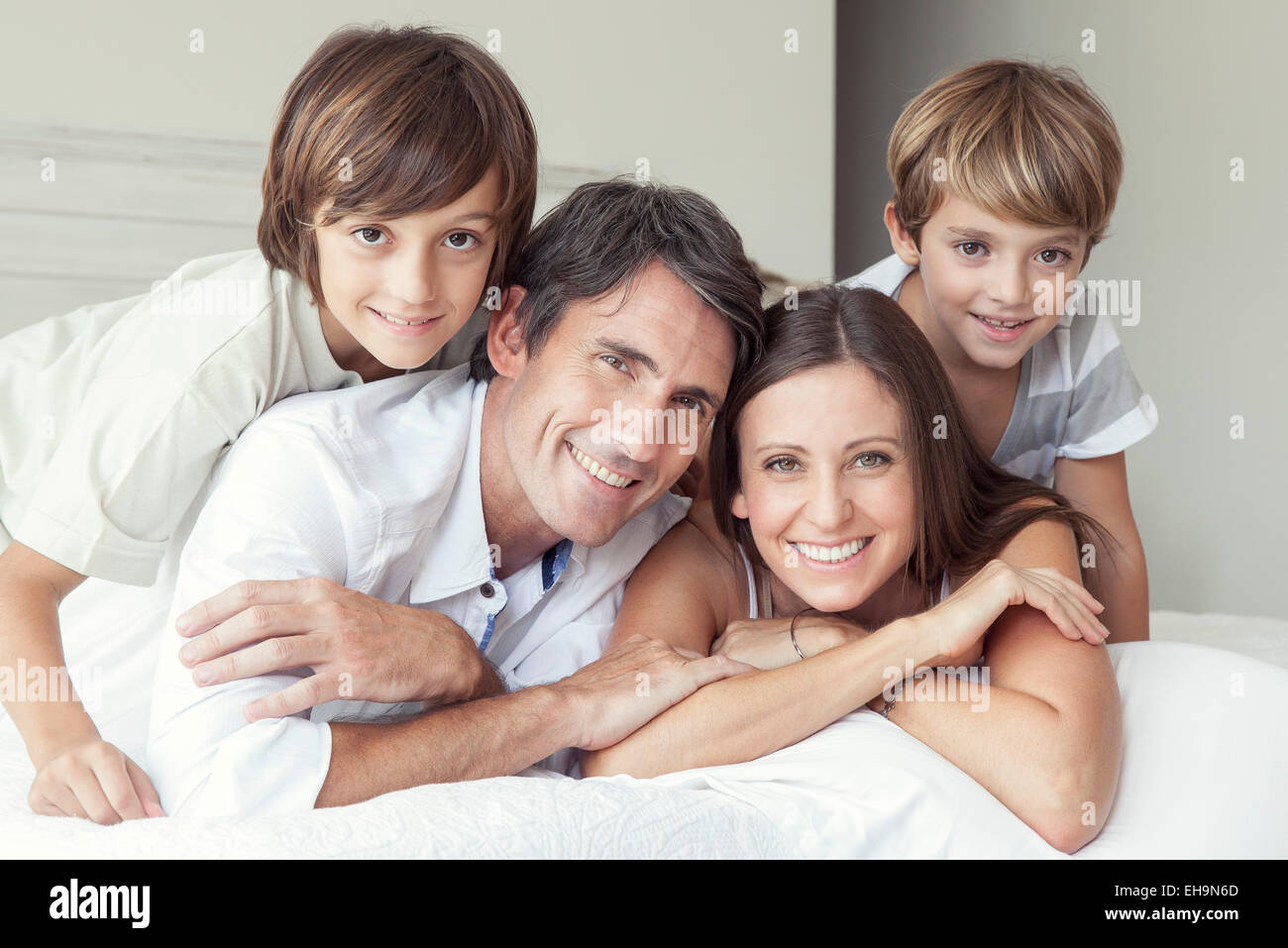 Family lying on bed, portrait Stock Photo
