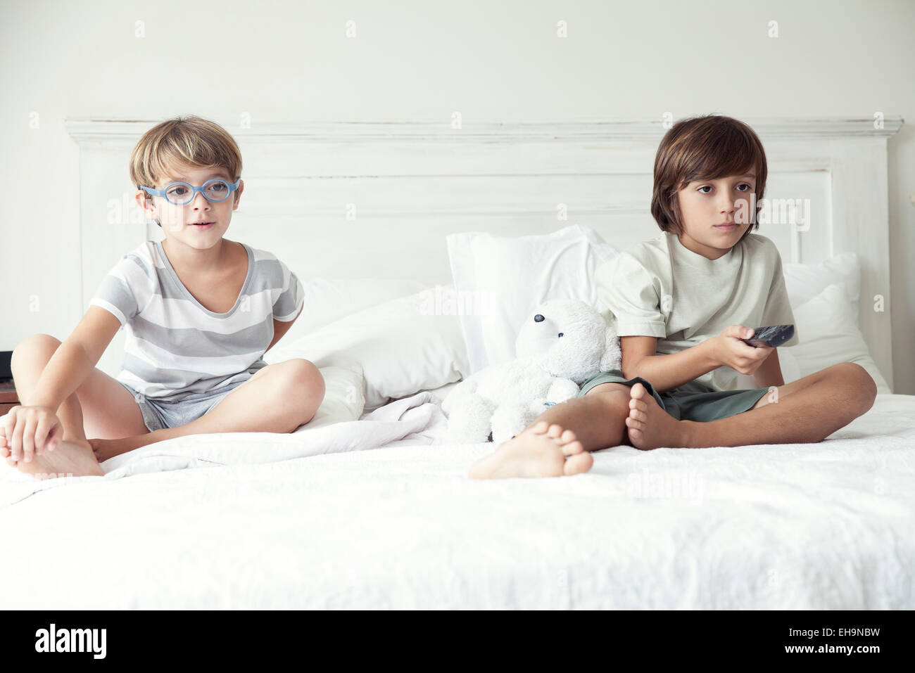 Boys watching tv on bed, portrait Stock Photo