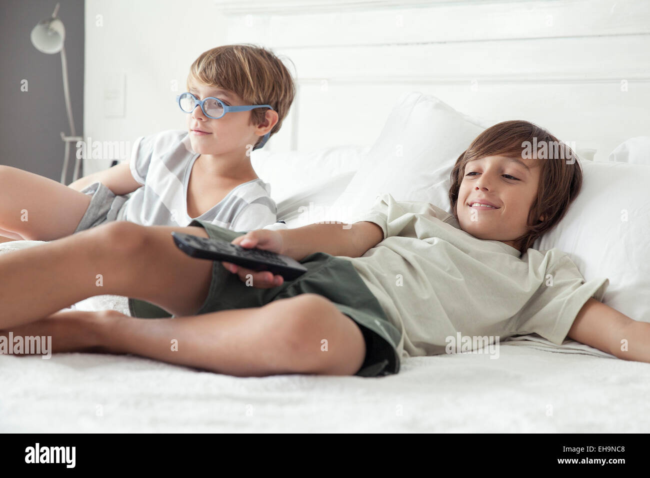 Boys watching TV on bed Stock Photo
