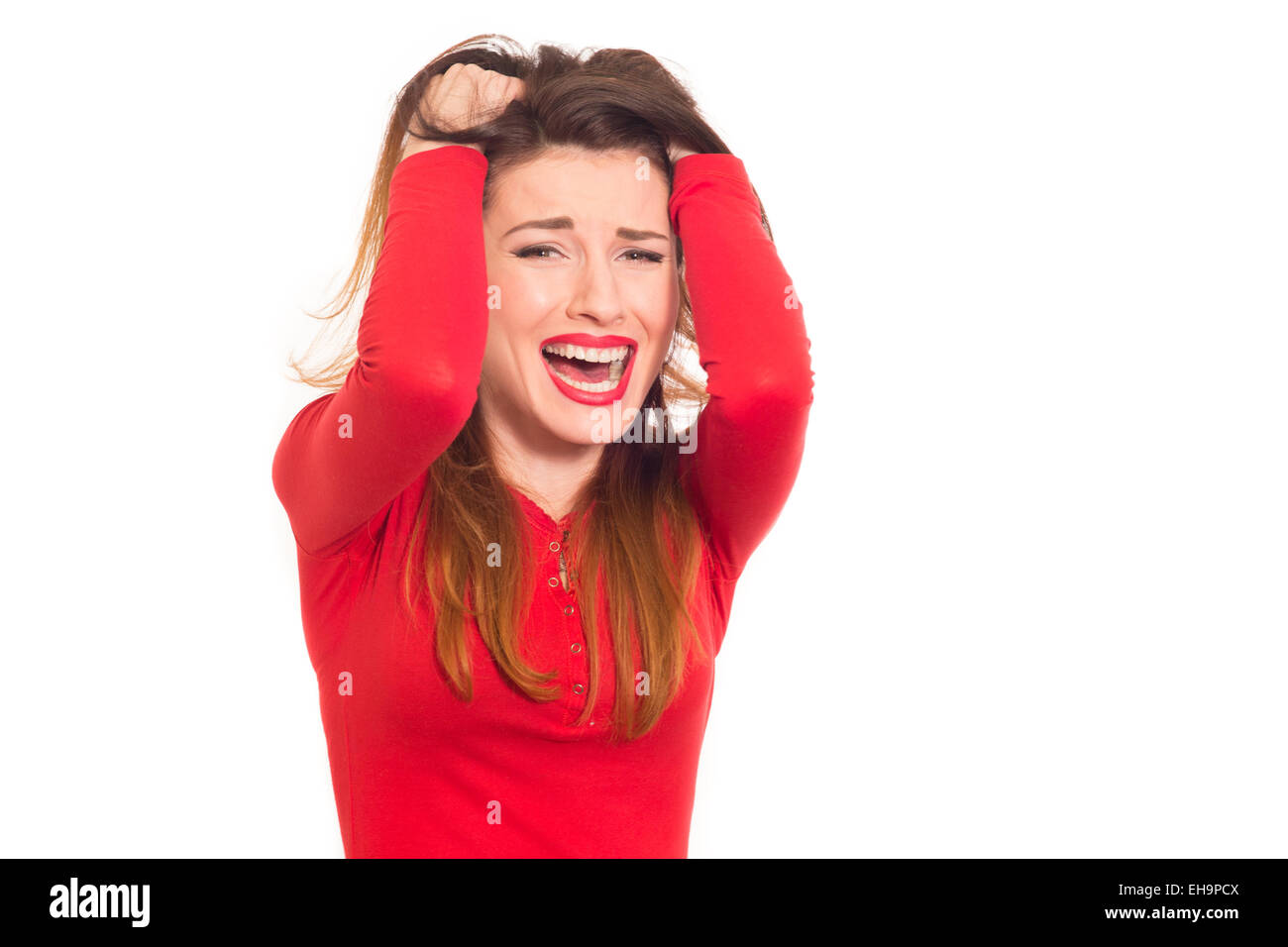 emotionally stressed woman in red grabbing her hair isolated Stock Photo