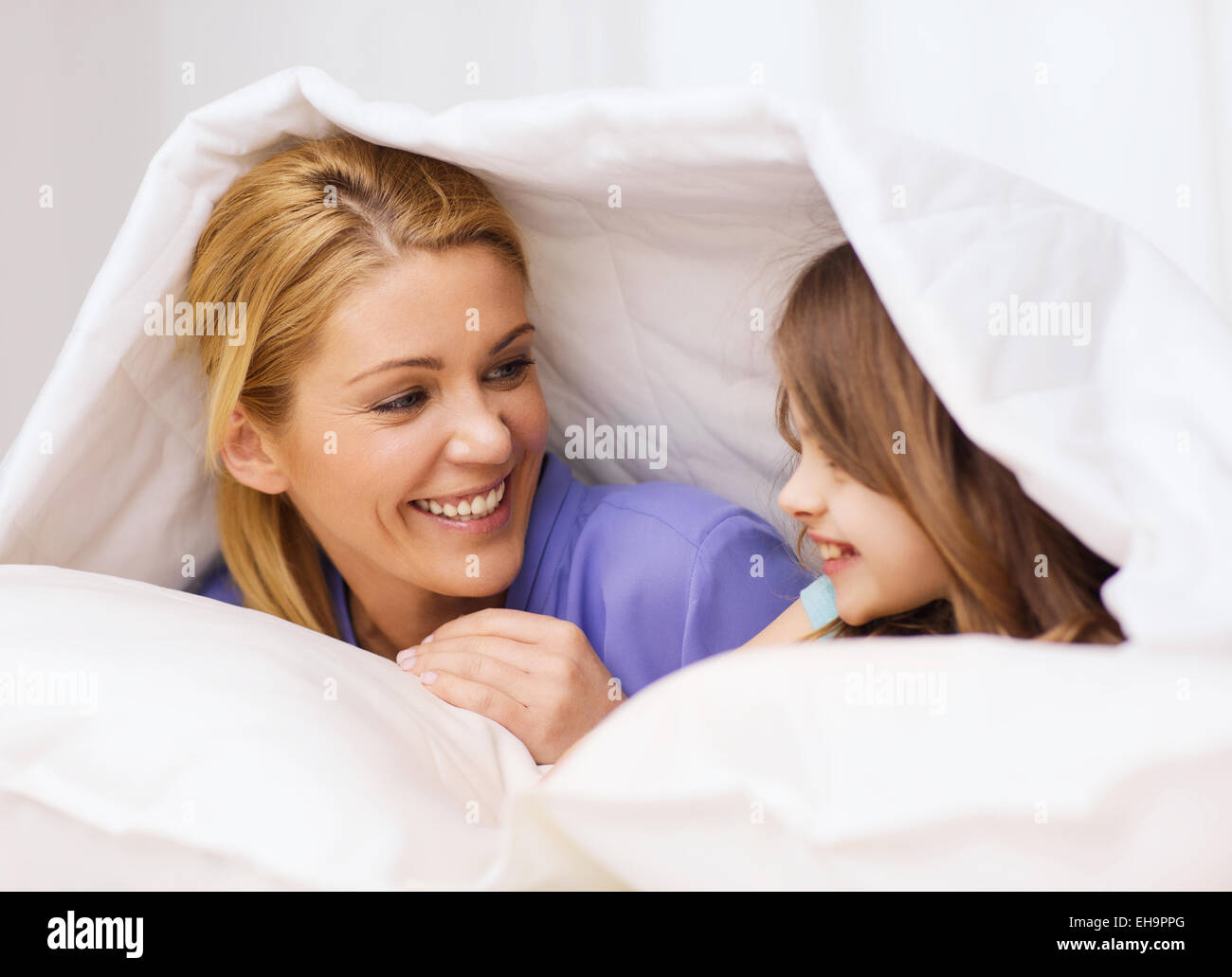 mother and little girl under blanket at home Stock Photo Alamy