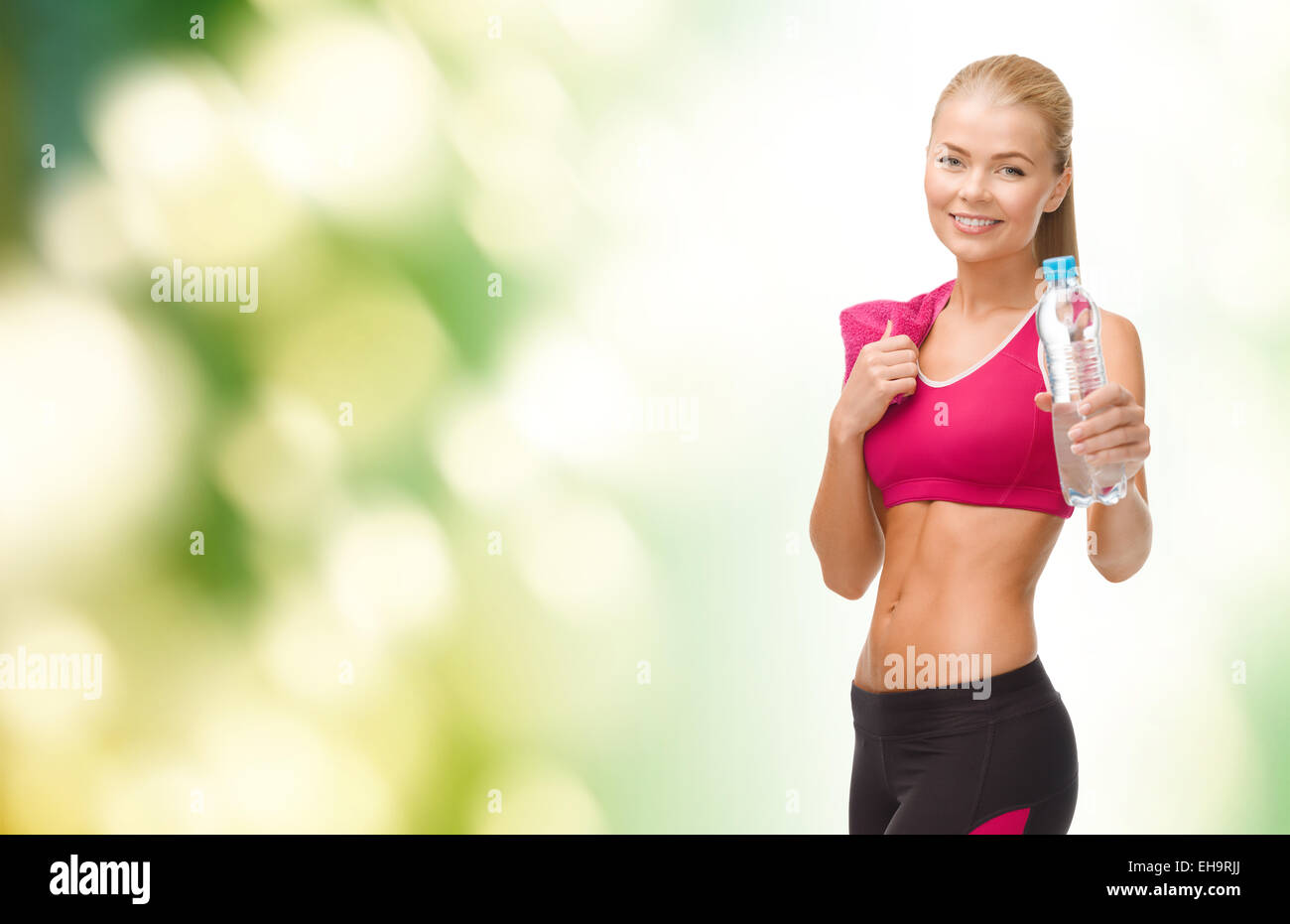 sporty woman with bottle of water and towel Stock Photo - Alamy