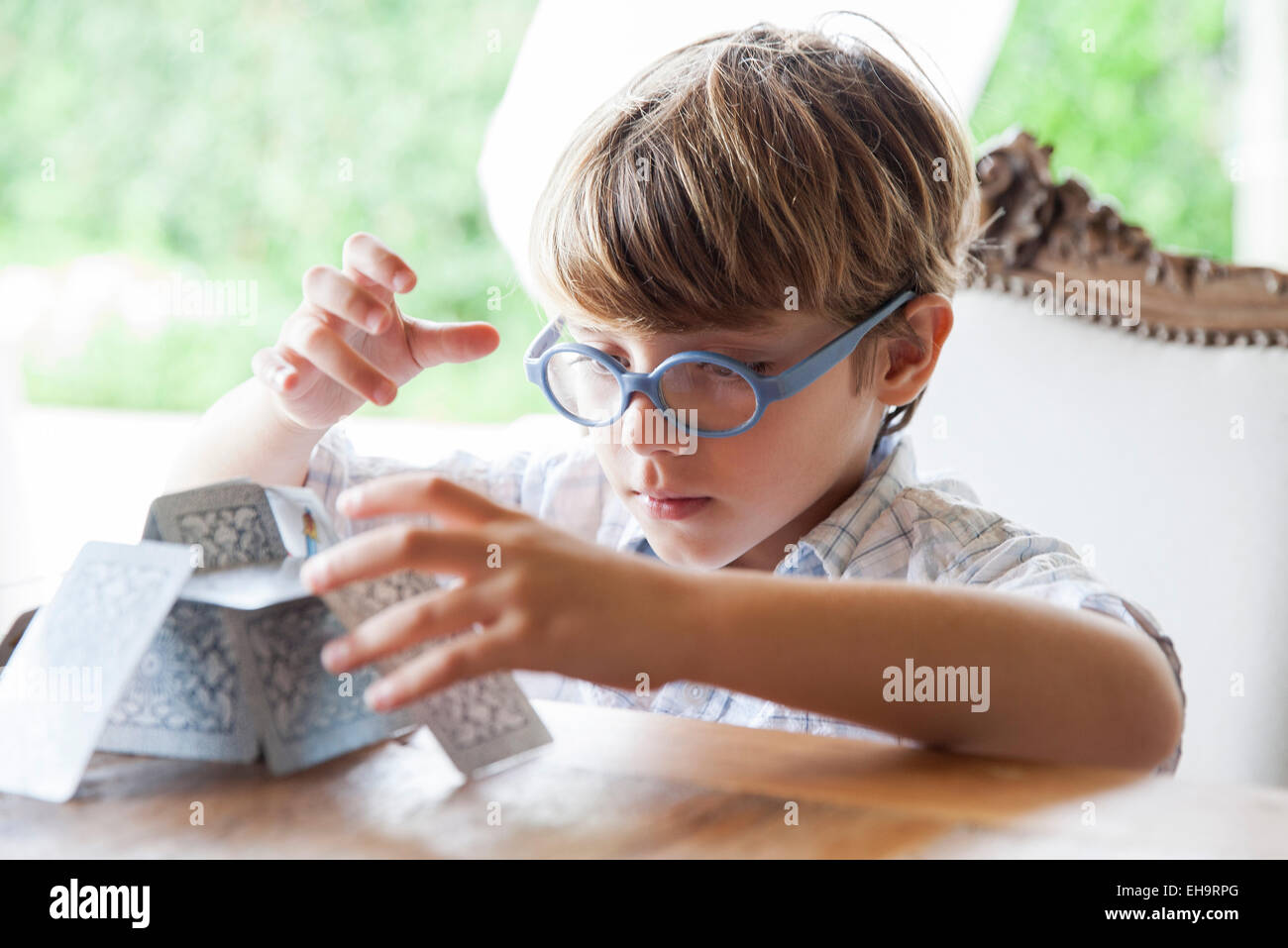 Little boy building house of cards Stock Photo