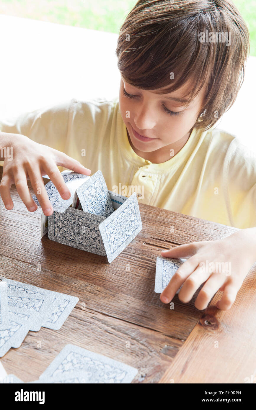 Boy building house of cards Stock Photo