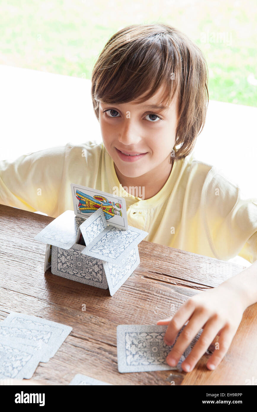 Boy building house of cards Stock Photo