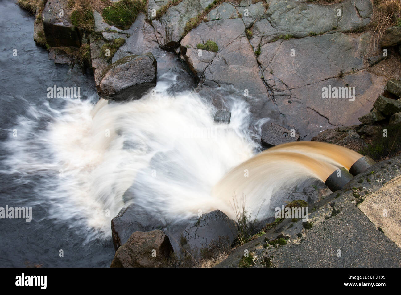 Overflow chute with runningh water from a small dam built to catch the water of a moorland stream. Stock Photo