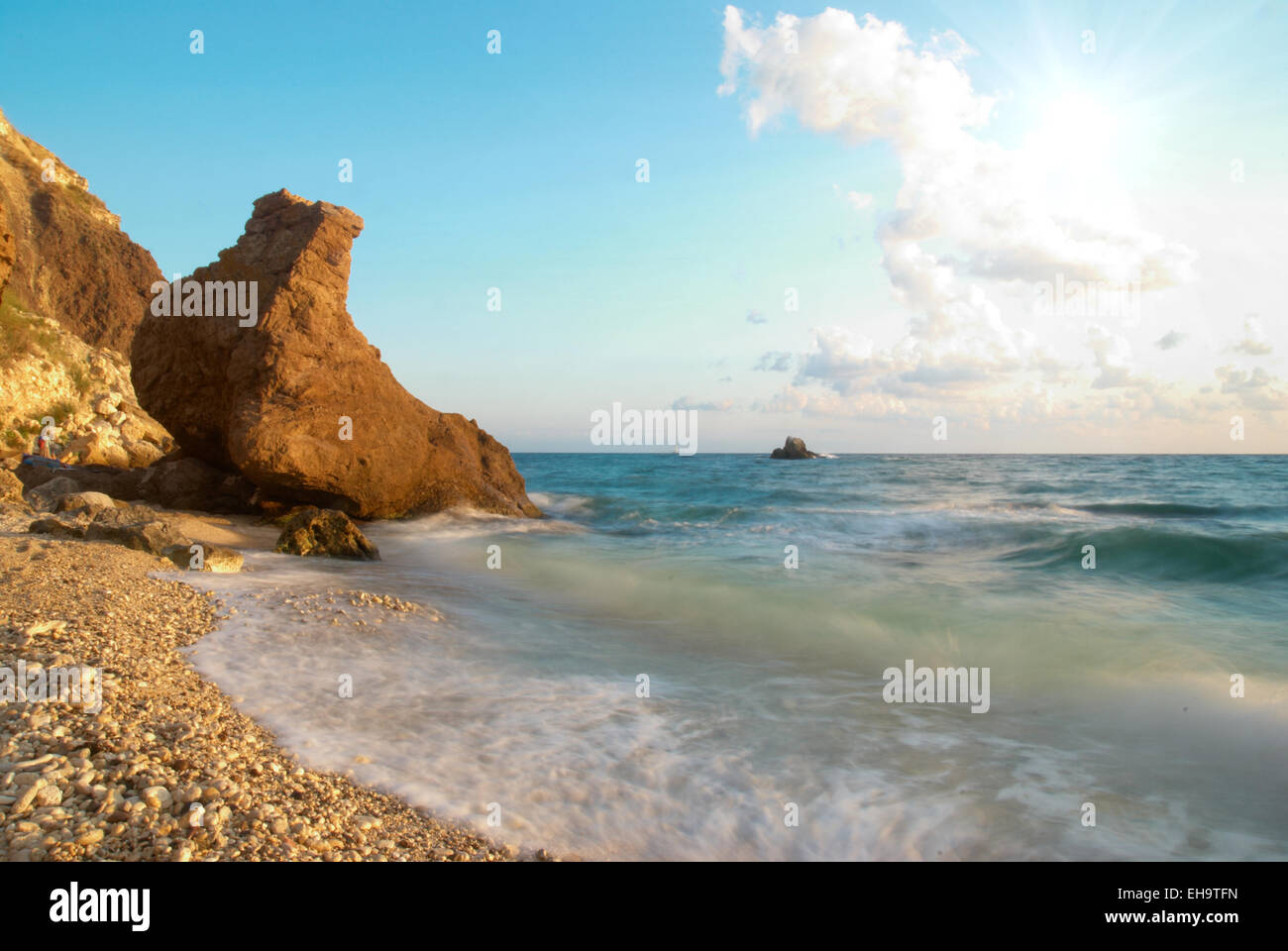 Tropical beach on the sunset with water and rocks Stock Photo - Alamy