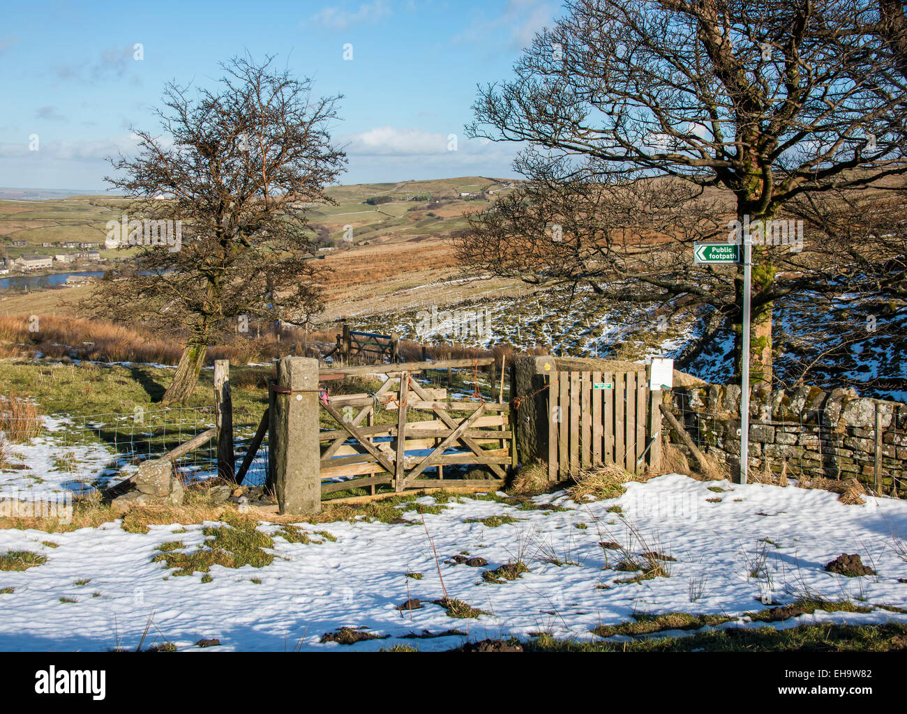 A signpost to a footpath through a wooden gate and across moorland in the South pennines close to Haworth in West Yorkshire Stock Photo