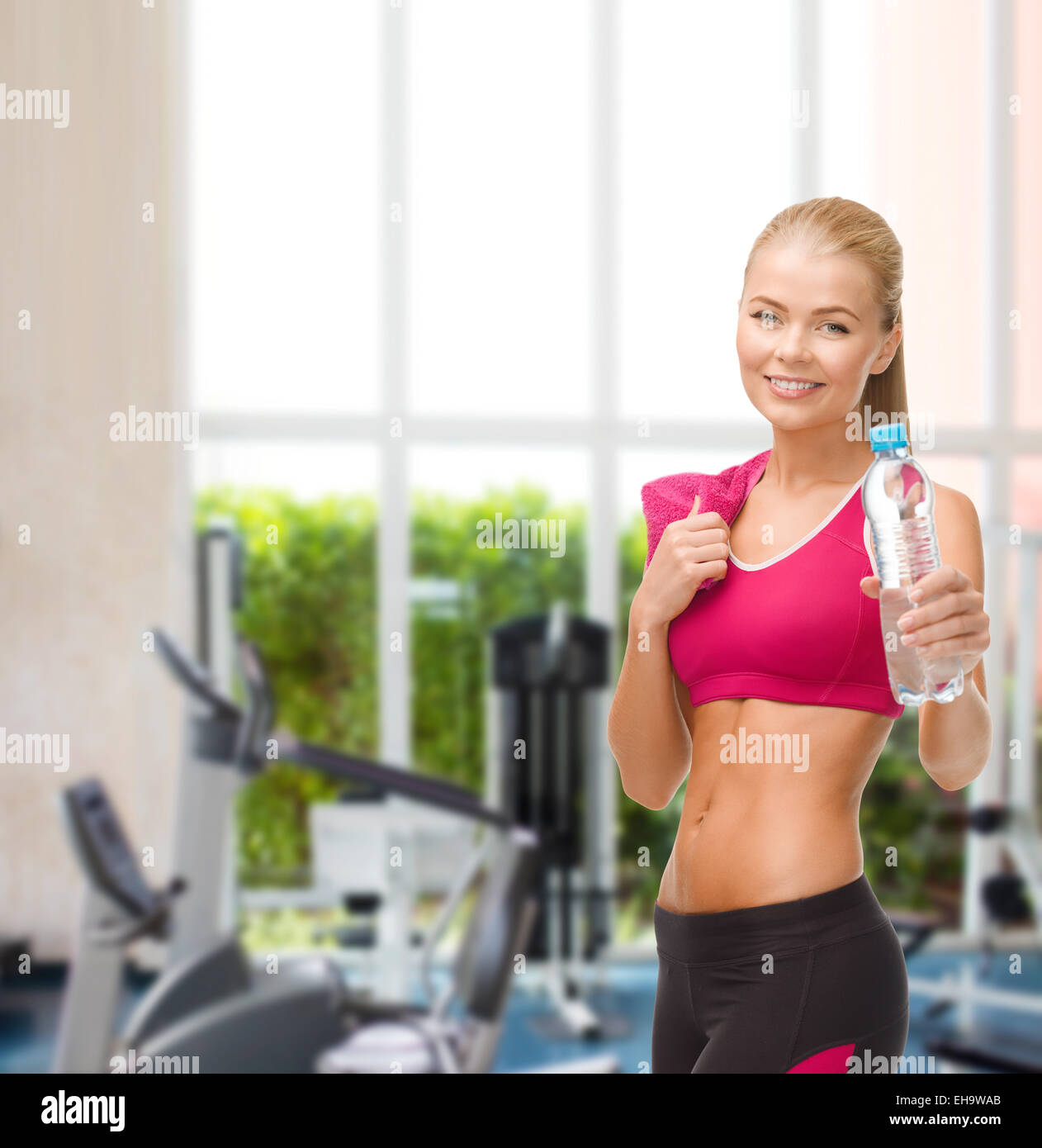 sporty woman with bottle of water and towel Stock Photo - Alamy