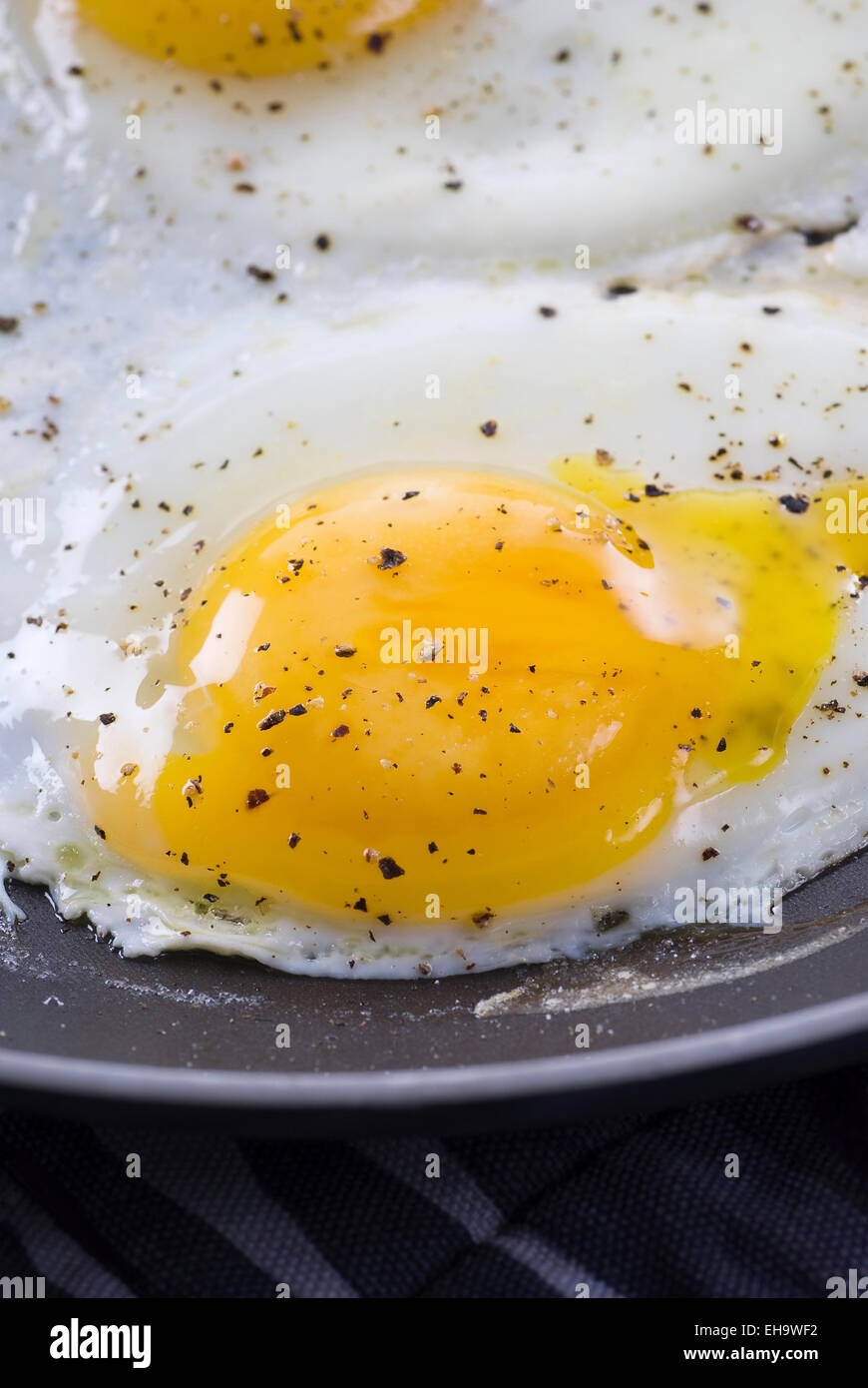 Fried eggs with salt and black pepper. Stock Photo