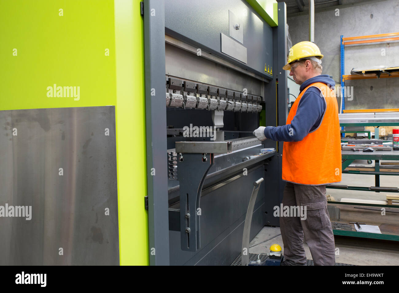 Metal industry worker operates CNC brake press machine Stock Photo - Alamy