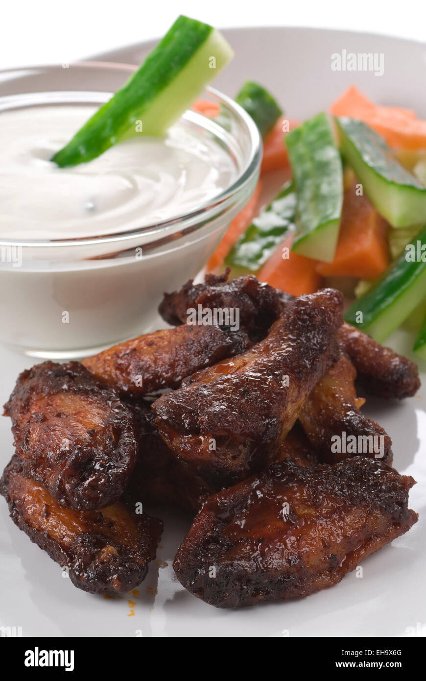 Spicy chicken wings with blue cheese dip, cucumber and carrot. Stock Photo