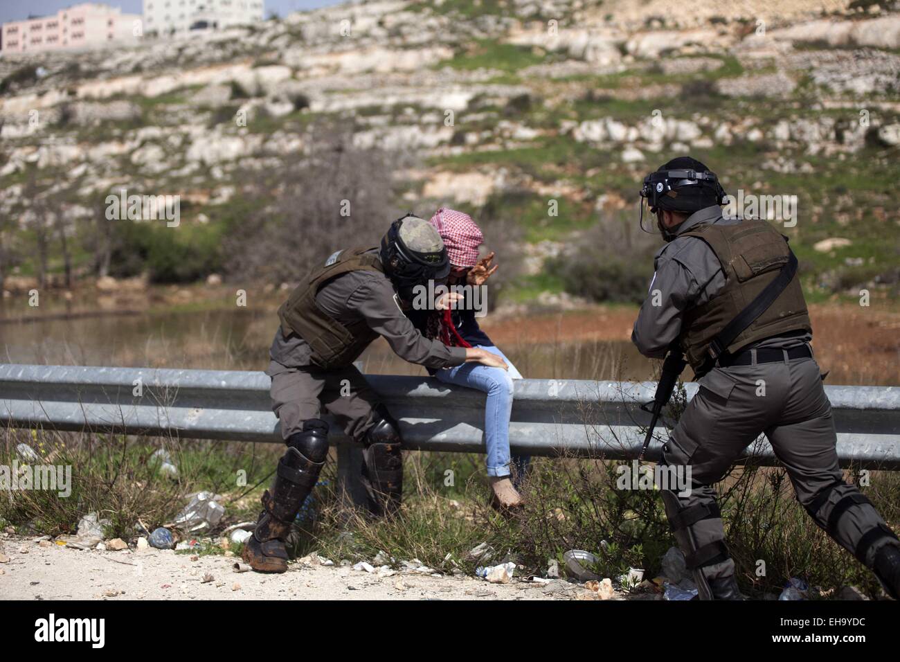 Ramallah, West Bank, Palestinian Territory. 10th Mar, 2015. Israeli border policemen detain a Palestinian girl during clashes at a protest calling for the release of Palestinian students held in Israeli jails, near Israel's Ofer Prison, near the West Bank city of Ramallah, March 10, 2015 Credit:  Shadi Hatem/APA Images/ZUMA Wire/Alamy Live News Stock Photo