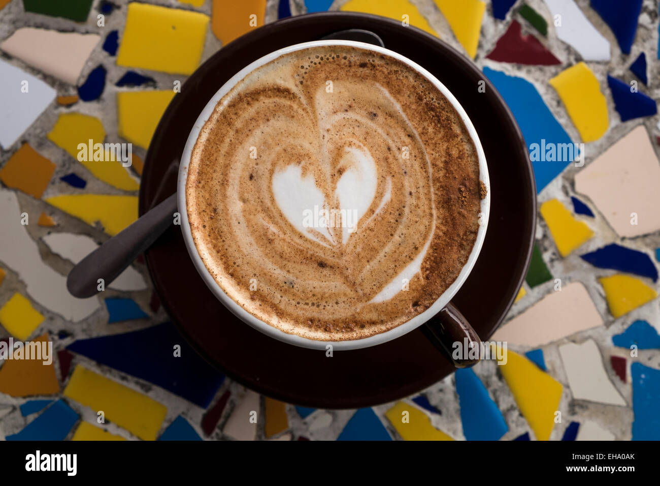 Overhead view of a cappuccino with a heart shape in chocolate sprinkled on top. Stock Photo