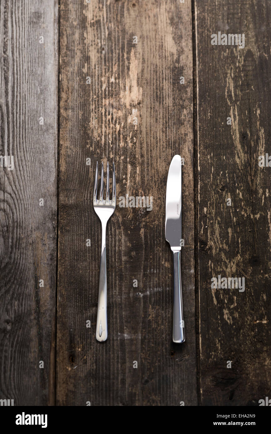 fork and knife on a dark wooden background Stock Photo - Alamy