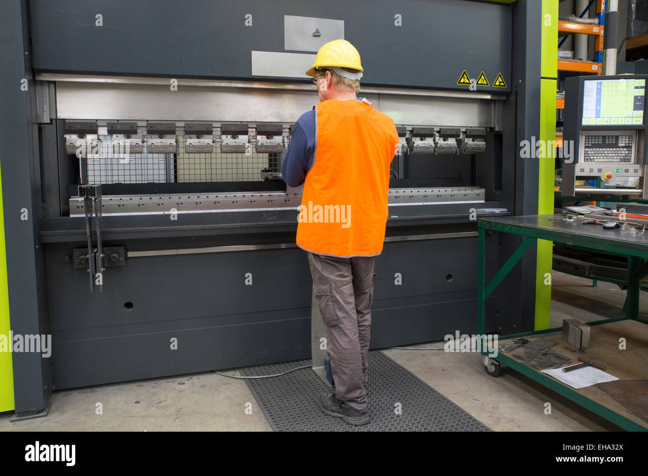 metal industry worker operates CNC brake press machine Stock Photo - Alamy