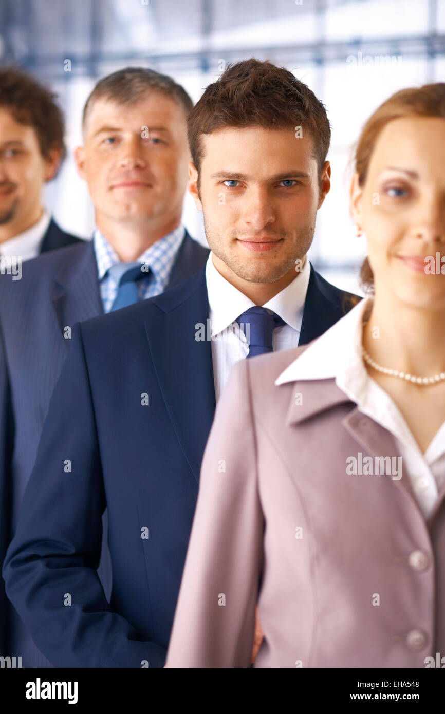 Closeup portrait of a young businessman standing in the row with his ...