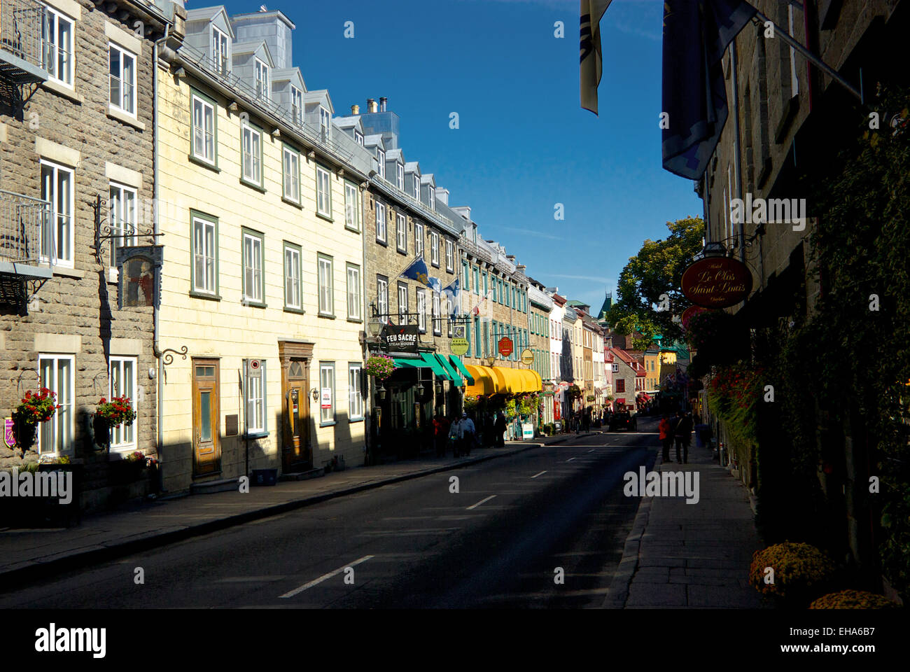 Early morning tourists walking shops and restaurants along Rue Saint-Louis in upper old Quebec City Stock Photo