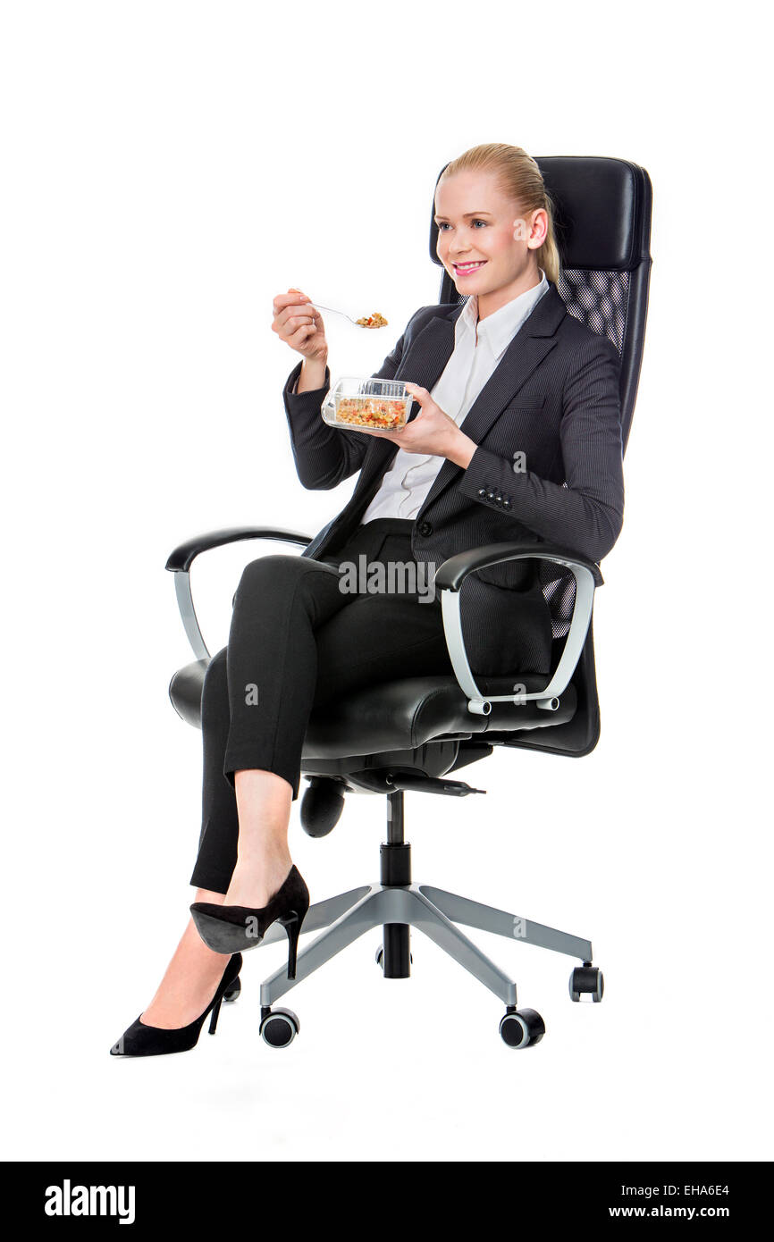 blonde businesswoman on a chair and having lunch Stock Photo