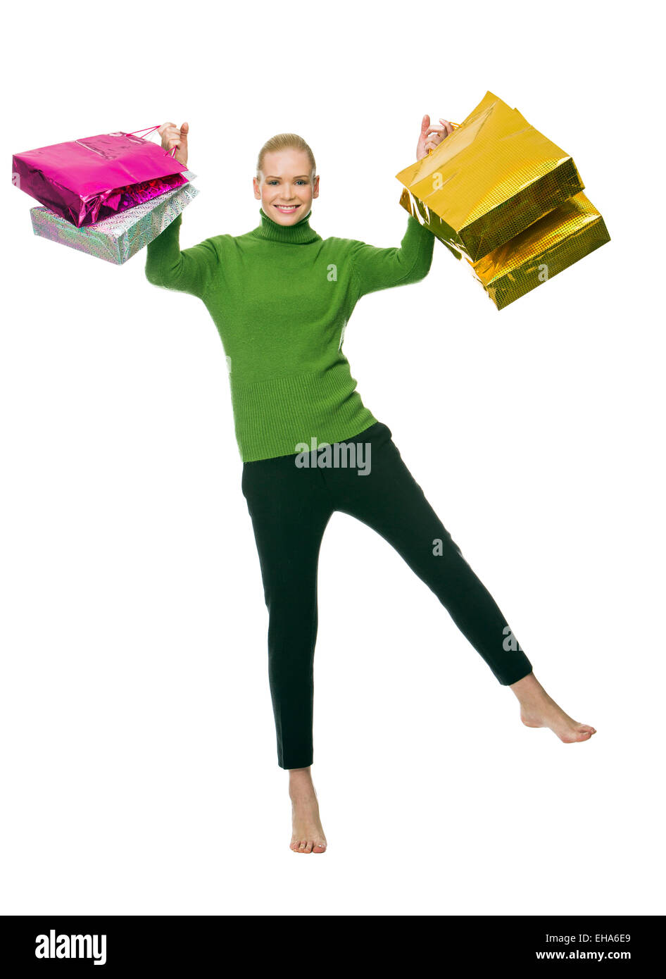 smiling woman with gift bags jumping Stock Photo